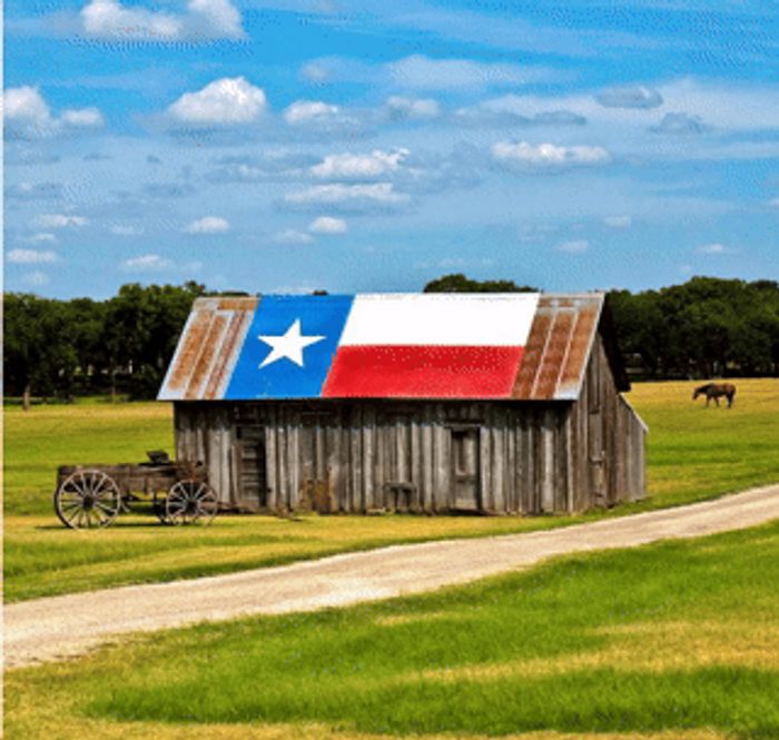 A rustic Texas barn with Lone Star flag roof — the spirit of The Homestead Cottage